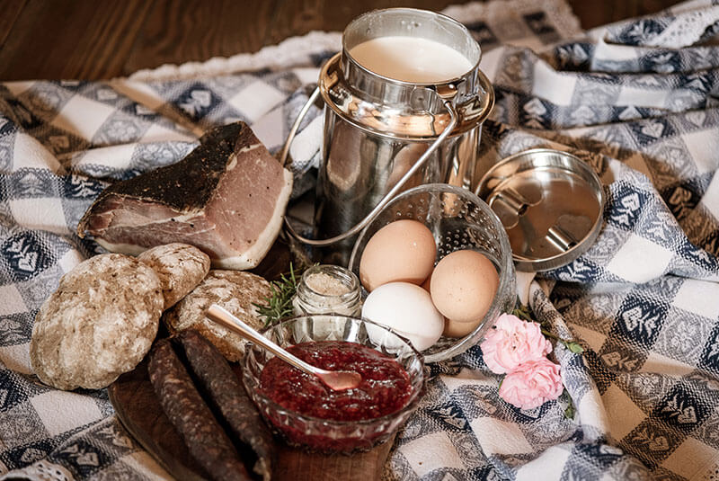Tisch mit frischen Produkten: Marmelade, Milch, Speck, Kaminwurze, Eier und Brot - Oberhof Weitental
