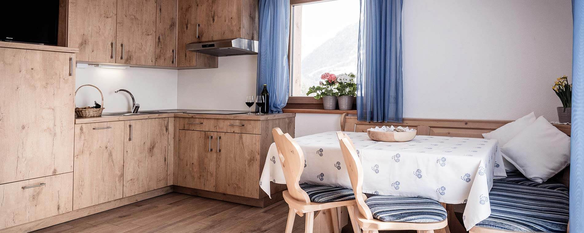 Küchennische mit Waschbecken und auf der rechten Seite eine Eckbank und ein Esstisch - Oberhof Weitental