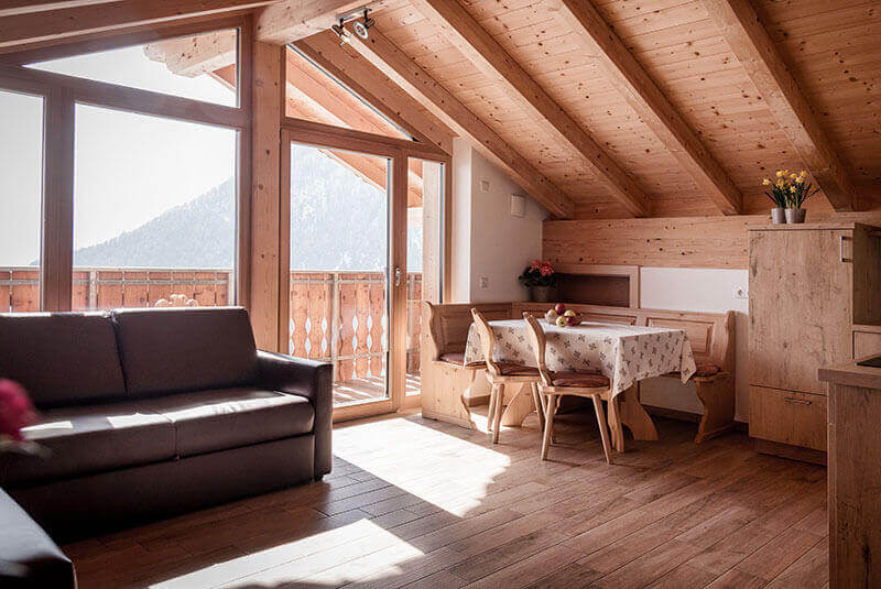 
Living and dining area with sofa, corner bench and table, on the left a wooden kitchenette - Oberhof Weitental